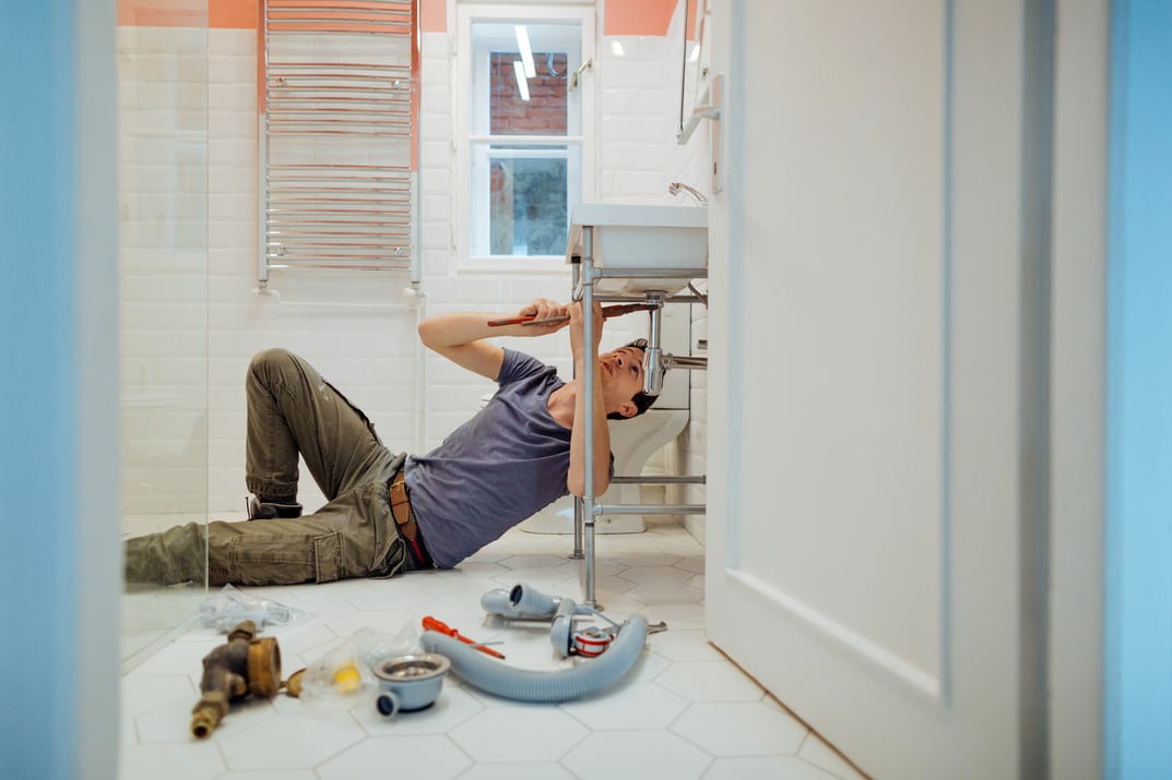 Man solving plumbing problems in his bathroom